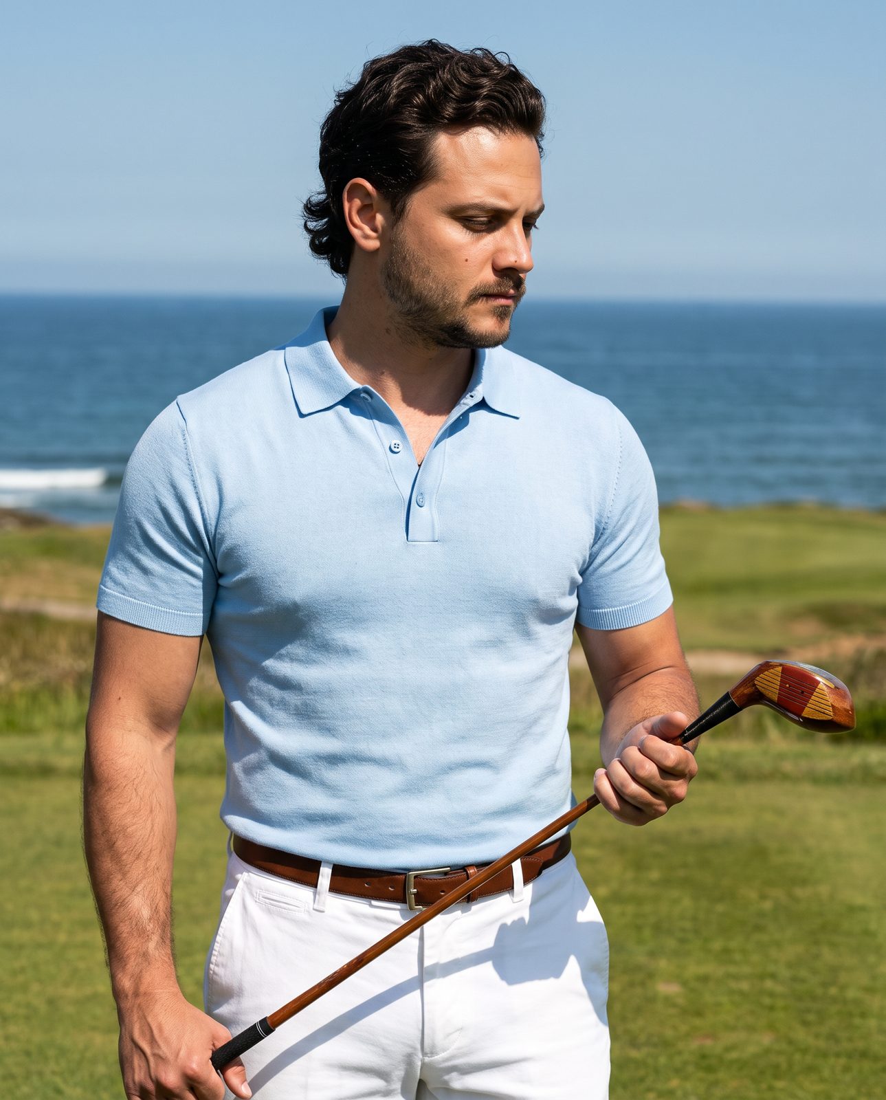 Golfer in a sky blue wool polo on a seaside tee